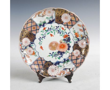 A Japanese Imari chrysanthemum-shaped dish, Meiji Period, decorated with chrysanthemum and foliage within a foliate panelled 