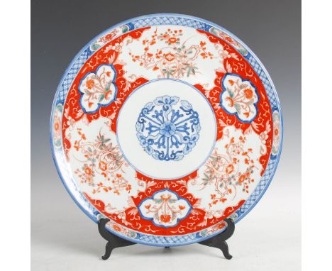 A Japanese Imari charger, Meiji Period, decorated with a central circular panel enclosing flower head and foliage, within a f