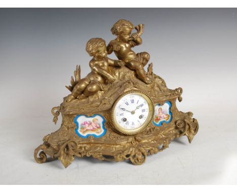 A late 19th century French ormolu and porcelain mounted mantle clock, the circular white enamel dial with Arabic and Roman nu