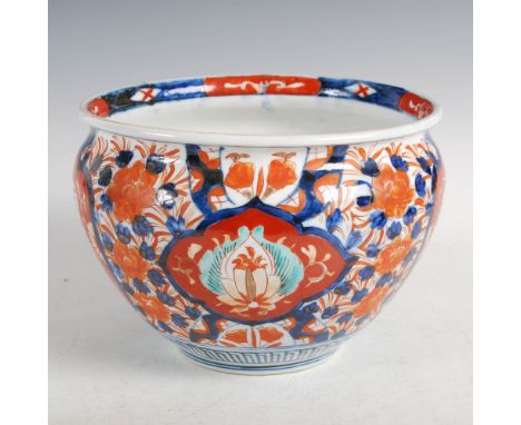 A Japanese Imari Jardiniere, Meiji Period, decorated with four shaped panels enclosing flowers on a ground of peony and folia