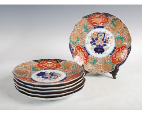 A set of six Japanese Imari plates, Meiji Period, of shaped circular form decorated with an urn issuing peony and foliage wit