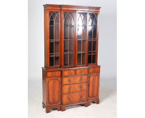 A reproduction mahogany breakfront bookcase in the George III style, the moulded cornice above four astragal glazed cupboard 