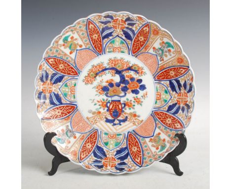 A Japanese Imari chrysanthemum-shaped charger, Meiji Period, decorated with a central circular shaped panel enclosing an urn 