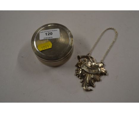 A white metal circular box and cover with gilded interior and a sherry decanter label 