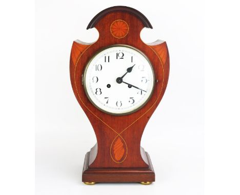 An Edwardian mahogany and inlaid mantel clock, of broken balloon shaped outline, inlaid with fan and conch shell medallions, 