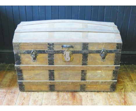 A metal bound dome topped steamer trunk, with leather carrying handles to the sides, 92cm wide. 