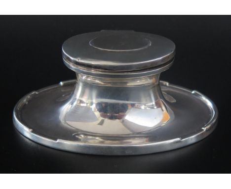 A George V silver inkwell, maker A &amp; J Zimmerman Ltd, Birmingham, 1924, of oval capstan form, with glass liner and weight
