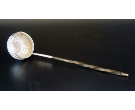 A Georgian silver toddy ladle, unmarked, the circular reeded bowl inset with George II sixpence, on a spiral twist baleen han