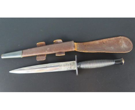 A Fairbairn Sykes fighting knife by Wilkinson Sword, with 17cm double edged blade, straight cross guard, ribbed grip containe