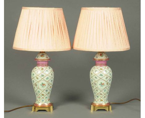A pair of porcelain lamp bases, with brass bases and pink shades, modern.  Height 22 ins.
 