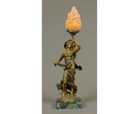 A figural table lamp, woman holding aloft a torch and raised on a marble base.  Height including shade 76 cm. 