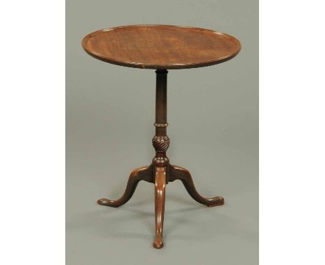 A George III mahogany tripod table, with circular dished top with snap action and turned and wrythen column with three downsw
