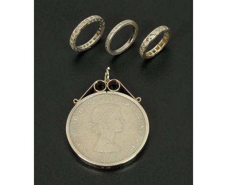 Three eternity rings, two 9 ct white gold and one silver, sizes H, K and L, and a Churchill crown 1965 in silver mount. 