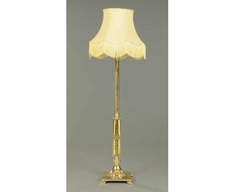 A brass standard lamp, adjustable, with cylindrical and square column and raised on a square bass with bracket feet (see illu