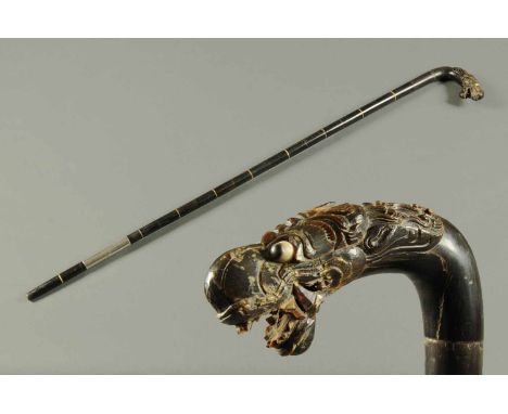 A Chinese horn walking stick, with carved dragon head handle.  Length 32.5 ins.  CONDITION REPORT: The dragon head handle has