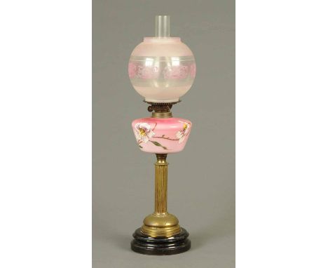 A Victorian brass column oil lamp, pink floral painted reservoir and etched shade.  