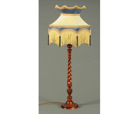 A mahogany table lamp, with twist column and octagonal fringed blue and cream shade.  Height 36 ins. 