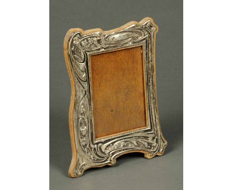 An Edwardian silver photograph frame, in the Art Nouveau style, Birmingham 1905, Registered 443080, with oak back.  Aperture 