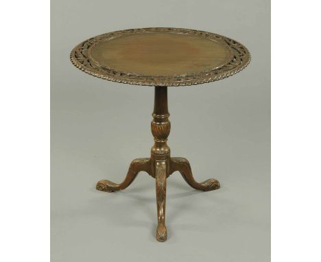A late Victorian tripod table, with foliate carved and pierced edge, snap action, turned column and three downswept legs term