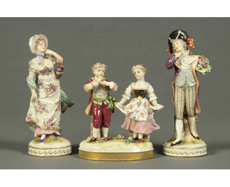 Three Continental porcelain figures, comprising a pair with the letter "R" in blue to base and figure group.  Heights from 7.