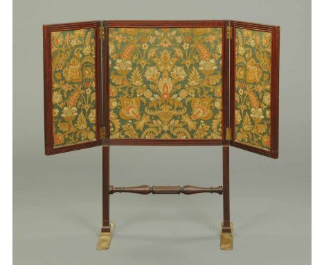 An early 19th century mahogany folding fire screen, with tapestry panels, centre stretcher and brass feet.  Width folded 22 i