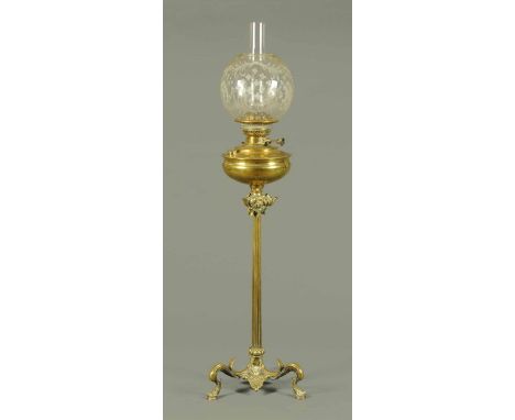 A brass oil lamp, raised on a fluted column with three scroll feet. Height 29 ins (see illustration).
  