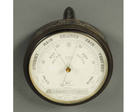 A late 19th century Wilson of Carlisle aneroid barometer, circular, with thermometer.  Diameter 9.5 ins.  CONDITION REPORT: T