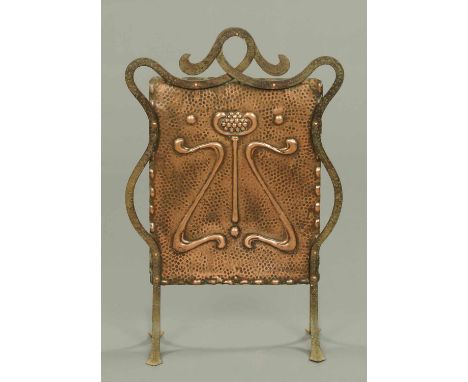 An Art Nouveau copper and ironwork fire screen, of shaped outline.  Width 21 ins. 