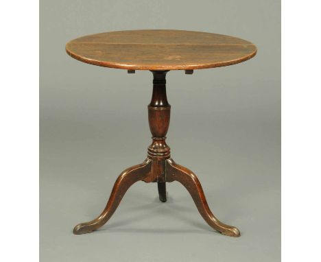 A George III oak tripod table, with snap action, turned column with three downswept legs terminating in pad feet.  Diameter 2