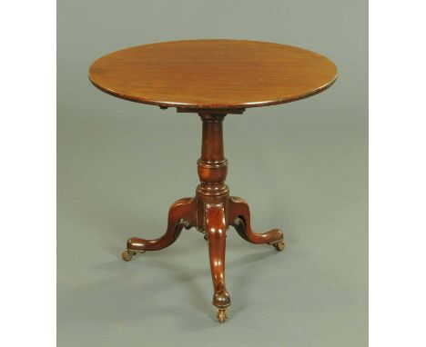 A George III mahogany tripod table, with turned support and three downswept legs terminating in castors.  Diameter 30.5 ins. 