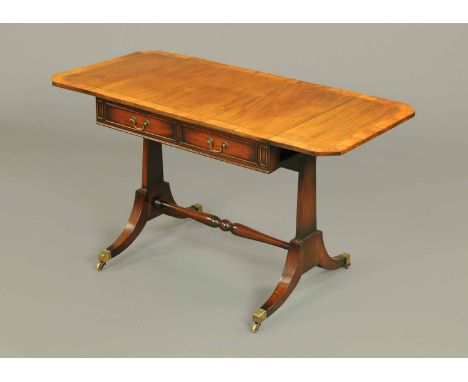 A Regency mahogany sofa table, with satinwood banded, boxwood and ebony strung edge and canted angles, fitted with two frieze