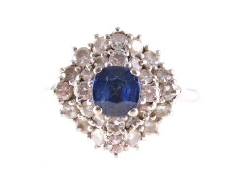 A sapphire and diamond cluster ring,  a cushion shaped sapphire claw set to centre and surrounded by twenty-eight brilliant c