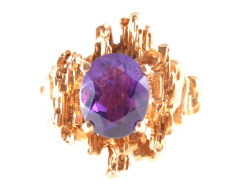 Two amethyst dress rings, an oval mixed cut amethyst 10.8mm x 8.8mm four claw set on a 9 carat yellow gold contemporary mount