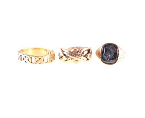 Three gold rings, a 9 carat yellow gold signet ring with intaglio carved haematite warriors head, a 9 carat yellow gold 5.5mm