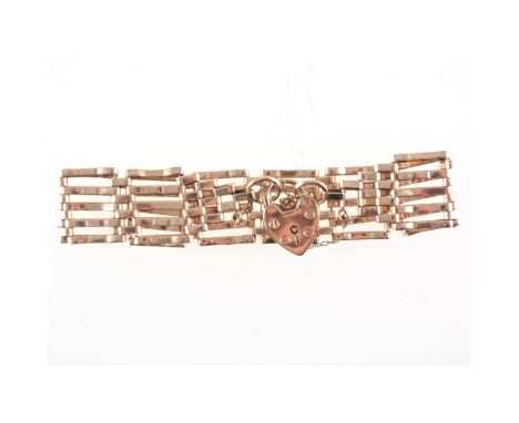 A 9 carat yellow gold bracelet, six bar crimped gate link design, 18mm wide fitted with a padlock fastener and safety chain, 