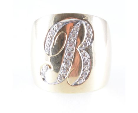 A wide yellow metal ring with the initial B pave set with twenty diamonds to the front, the band tapering from 8mm at the bac