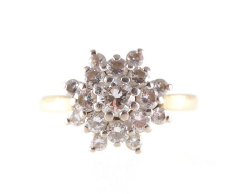 A circular diamond cluster ring, a single brilliant cut diamond claw set to centre and surrounded by sixteen brilliant cut di