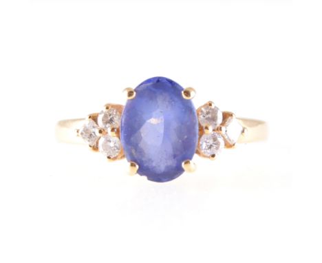 A tanzanite and diamond ring, the oval faceted tanzanite 8.7mm x 6.7mm, four claw set with two brilliant cut and one princess