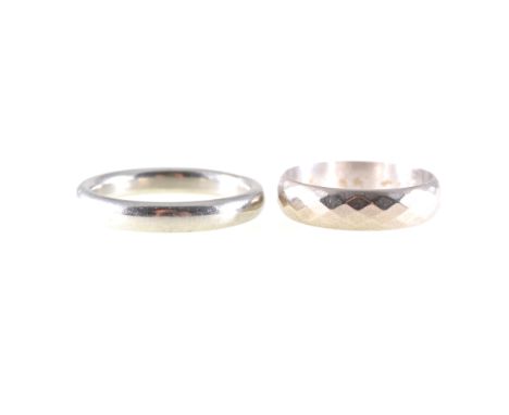 Two white metal wedding bands, a 3.5mm wide band, plain polished finish, stamped 18ct, approximate weight 7gms, ring size S, 