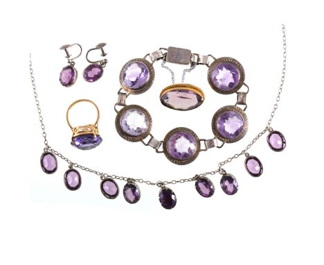 A collection of jewellery with purple stones, a ring claw set with a 16.5mm synthetic corundum (made to simulate alexandrite)