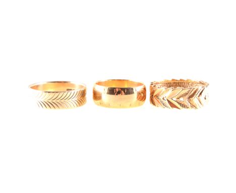 Three 9 carat yellow gold fancy wedding rings, a 7.5mm wide polished D shape band with etched border ring size M, a 6.3mm wid