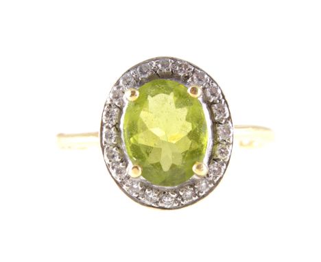 A peridot and diamond oval cluster ring, an oval mixed cut peridot 10mm x 8mm, four claw set and surrounded by twenty brillia