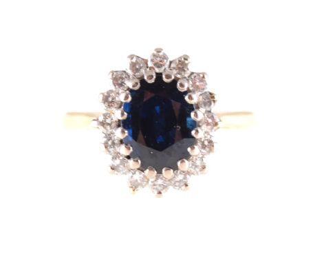 A sapphire and diamond oval cluster ring. the oval faceted sapphire 9mm x 7mm, claw set and surrounded by sixteen brilliant c
