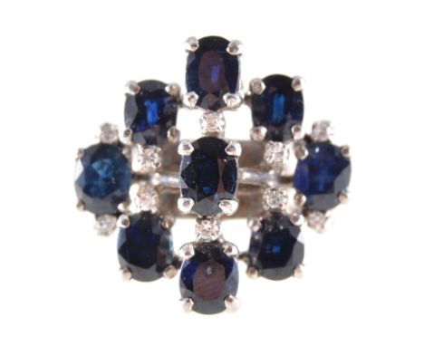 A modern sapphire and diamond cluster ring, nine oval mixed cut sapphires and ten small brilliant cut diamonds, individually 