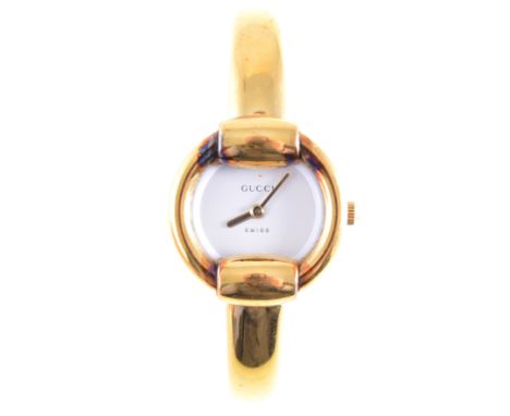 Gucci - A Lady's bangle watch, plain circular white dial in a polished gold-plated on stainless steel case on a plain 7mm wid