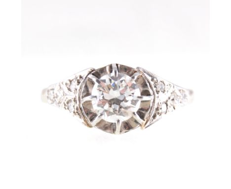 A diamond solitaire ring, the brilliant cut stone set with eight raised claws in an all white metal mount, plain 2mm wide sha