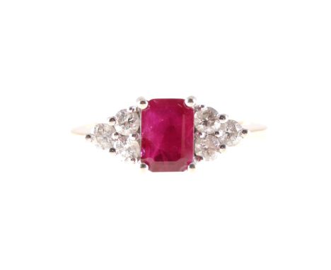 A ruby and diamond three stone ring, a rectangular step cut ruby 7mm x 4.3mm set with four corner claws, with three brilliant