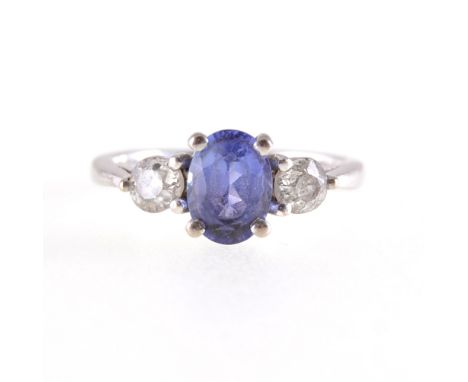 A tanzanite and diamond three stone ring, an oval mixed cut tanzanite 7.2mm x 5.5mm, four claw set with an old brilliant cut 