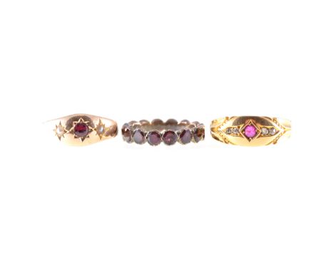 Three dress rings, an 18 carat yellow gold gypsy set ring set with a ruby and four small rose cut diamonds, hallmarked Birmin