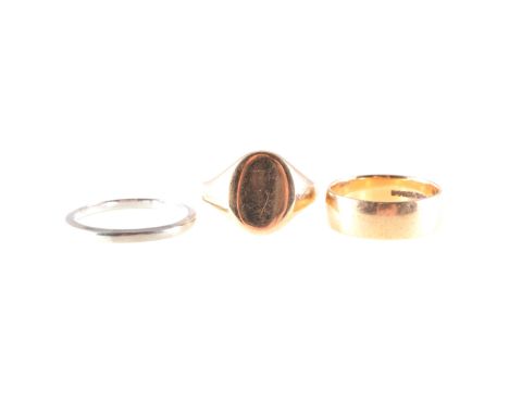 Three gold rings, an 18 carat white gold wedding band, 2.1mm wide, approximate weight 3.4gms, ring size V, a 9 carat yellow g